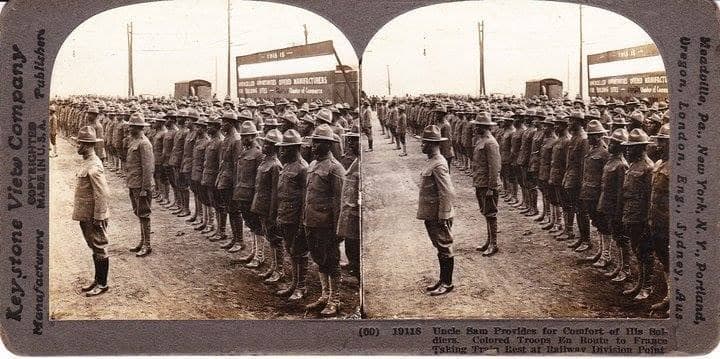 Keystone View Company stereoscopic photo card showing two side-by-side images of long rows of soldiers standing in formation, with officers reviewing the line.